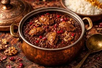 خورشت فسنجان با مرغ در قابلمه با رنگ تیره و لعاب دار
