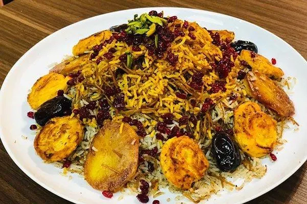 لایه‌های برنج، گوشت، کشمش و زرشک در قابلمه