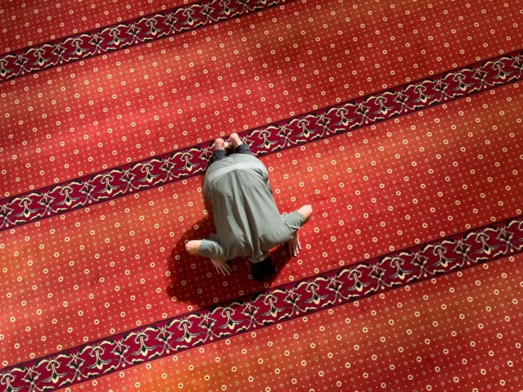 نمازگزار با مانتو در حال نماز خواندن