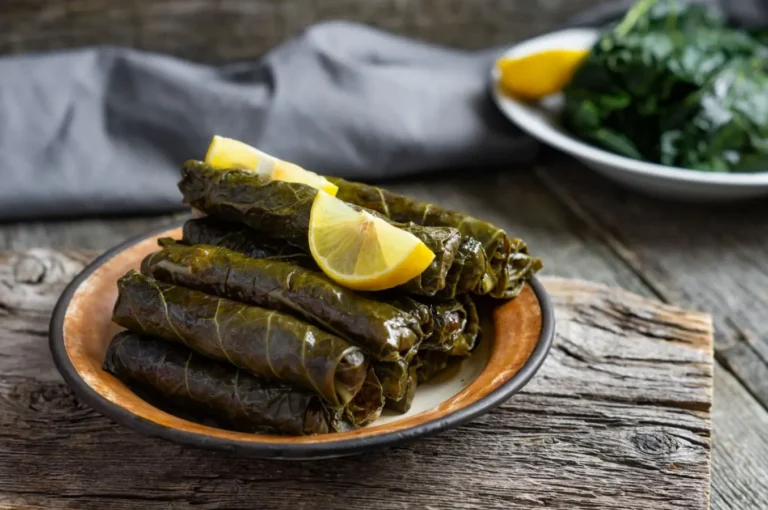 دلمه برگ مو لرستانی با باقلا و ماست در ظرف سفالی