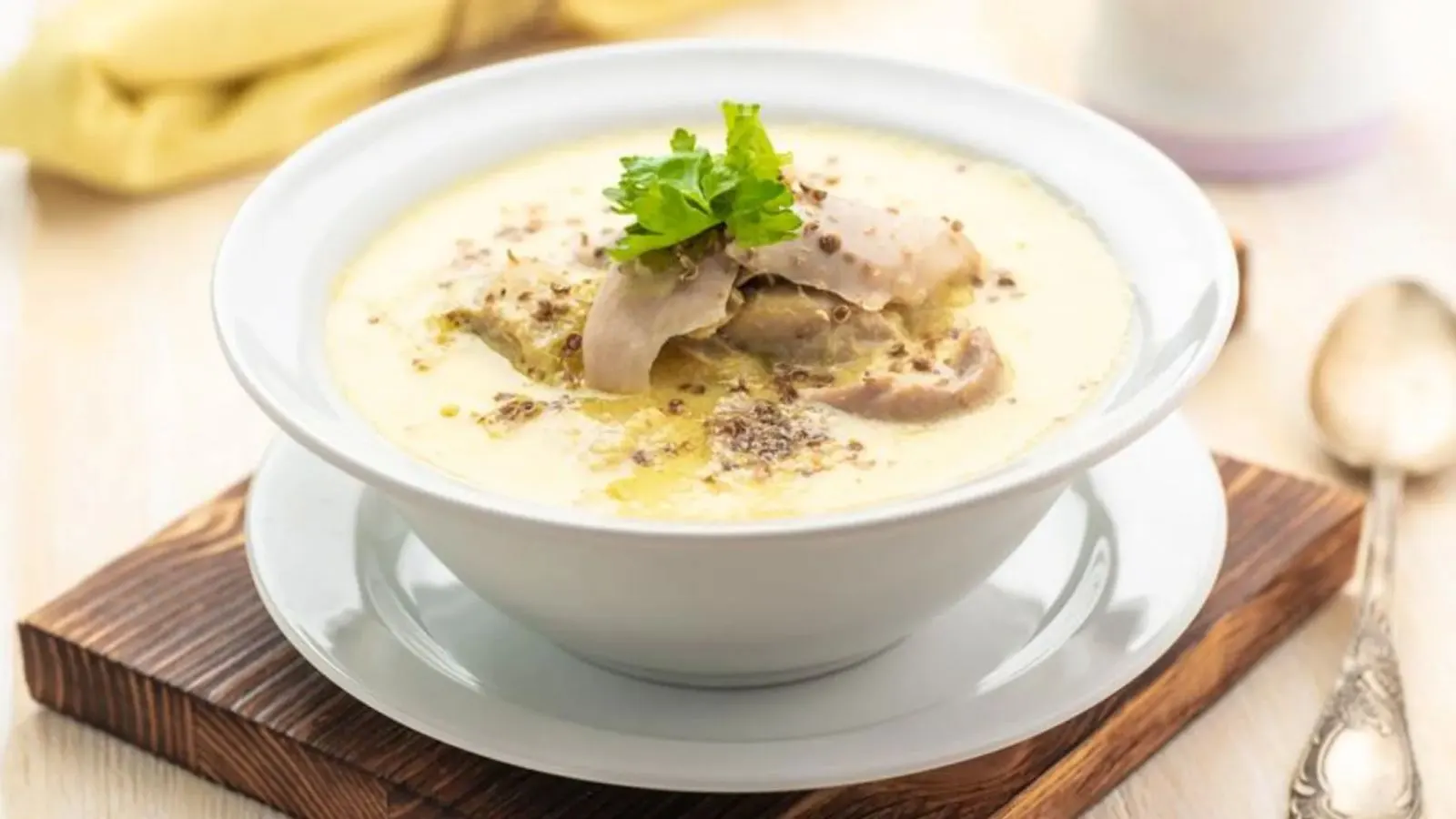 طرز تهیه سوپ شیر؛ کاسه‌ای از سوپ شیر خامه‌ای با تزیین جعفری و قارچ