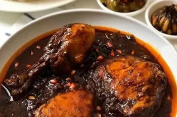 خورش سیر انار مازندرانی با رنگ قرمز و دانههای انار تازه