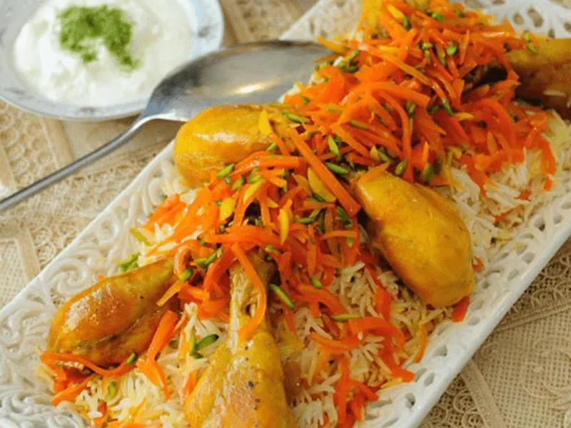 هویج پلو مجلسی با تزیین زرشک و خلال پسته در دیس