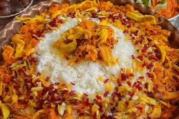 هویج پلو مجلسی با مرغ، زعفران و زرشک در ظرف سرو