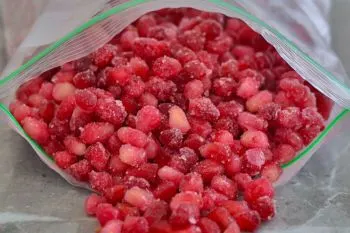 فریز کردن دانه انار؛ دانههای انار روی سینی پوشیده شده با کاغذ روغنی