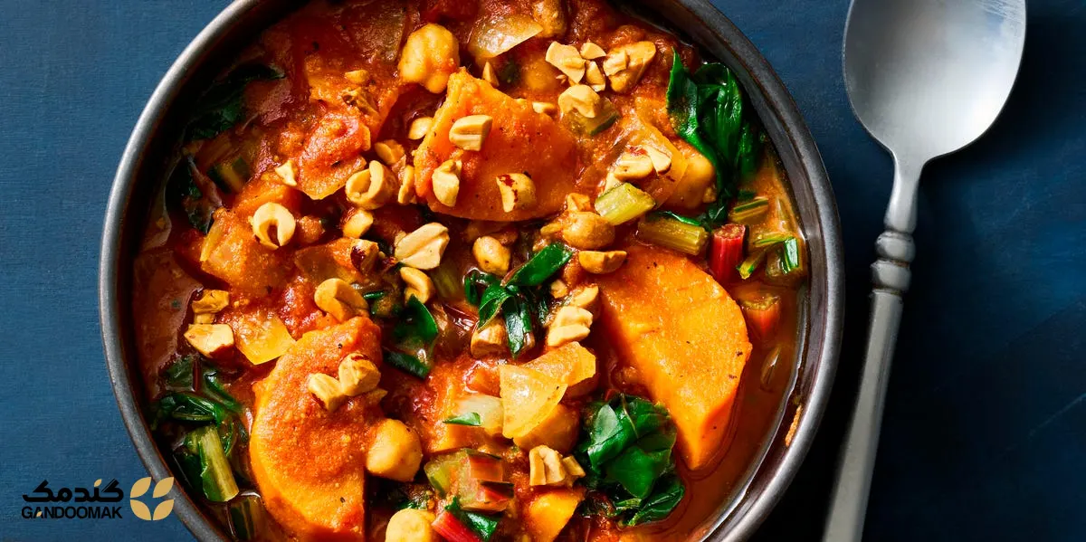 خورش شیرین سیب‌زمینی و بادام‌زمینی؛ کاسه‌ای پر از خورش سبزیجات گرم