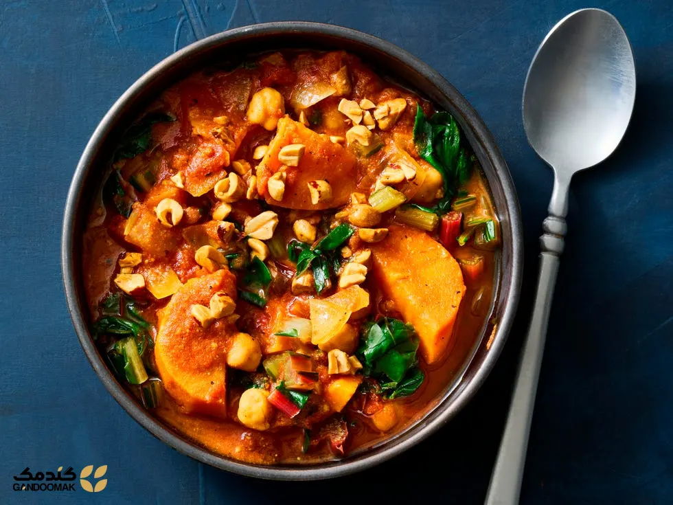 خورش شیرین سیب‌زمینی و بادام‌زمینی؛ کاسه‌ای پر از خورش سبزیجات گرم