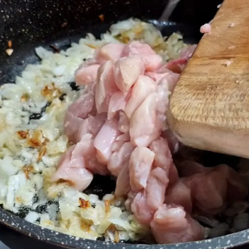 مرغ و پیاز در حال تفت دادن برای ترکیب طعمها